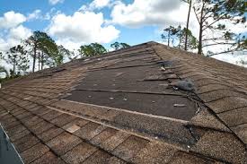 Aerial view of a Florida home with extensive hurricane roof damage and exposed underlayment